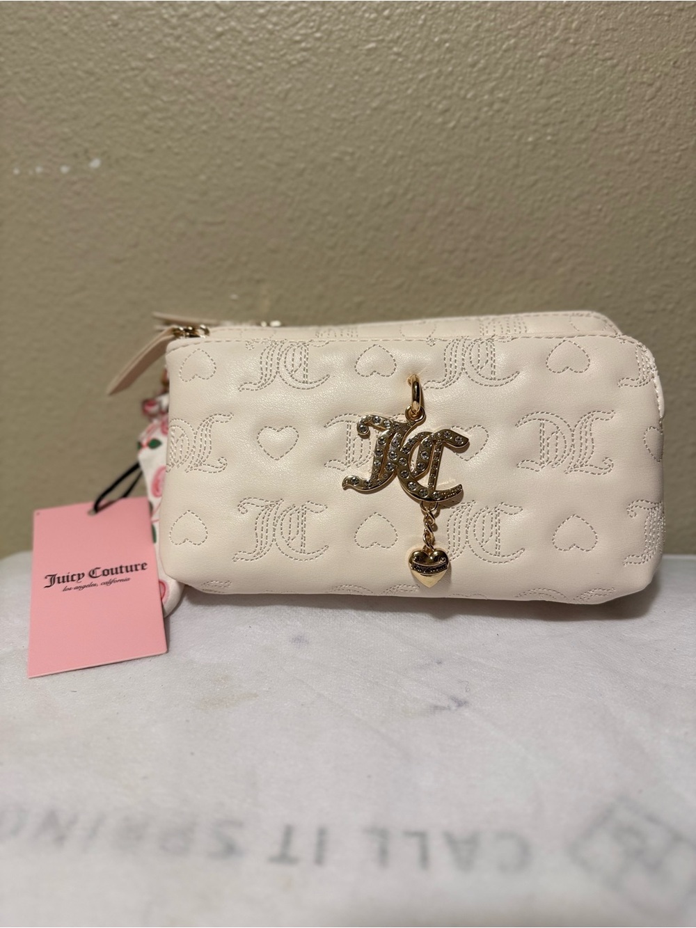 Juicy Couture white wristlet features a quilted design with stitched hearts
